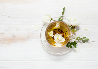 Tea with garden roses in a transparent cup