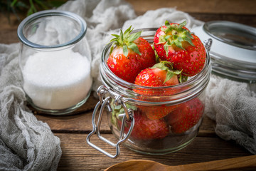Strawberry in jar on wooden background.