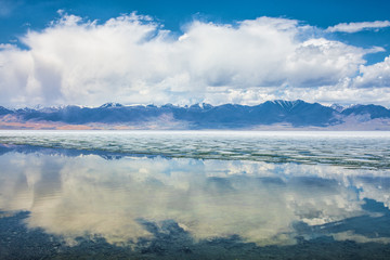 Fototapeta premium panoramic view of fluffy white clouds reflecting in watery surface of lake 