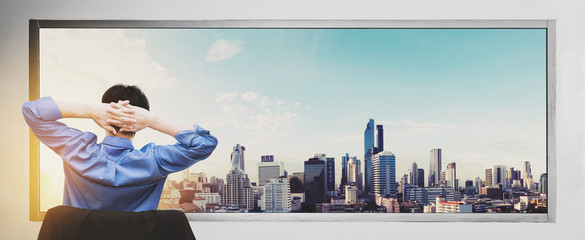 Fototapeta na wymiar a man stretching arm relax with cityscape view in sunrise through window 