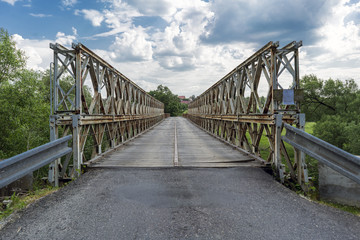 Fototapeta na wymiar Old metal military bridge on the entrance road to the village of Kacov, Czech Republic