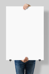 Woman holding a blank A1 poster mockup isolated on a gray background.
