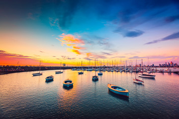 Yachts anchored in a row at sunset