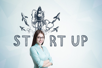 Young woman in blueish shirt, startup rocket