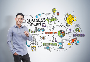 Asian businessman holding glasses, business plan