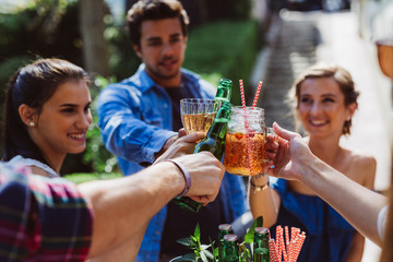 Freunde stoßen mit Getränke an - Party im Garten