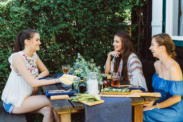 Drei Frauen draußen am Tisch mit Essen