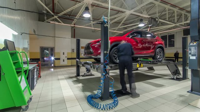 Car on stand with sensors on wheels for wheels alignment camber check in workshop of Service station timelapse.