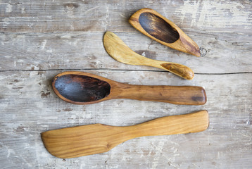 old handmade wooden spoons on old rustic kitchen table