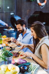 Man at smoker and friends at table cheering