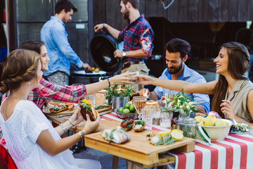 Man at smoker and friends at table cheering