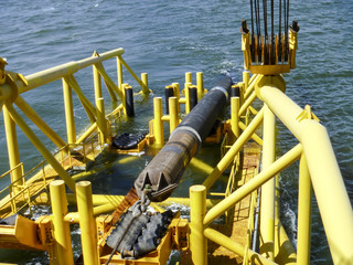 Laying of pipes with pipe-laying barge crane near the shore. Descent of the pipeline to a bottom...