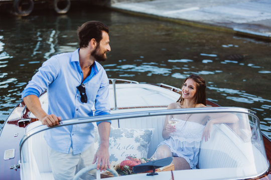 Handsome captain with girl in boat on lake