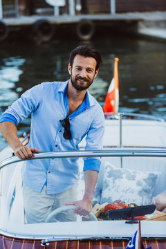 Handsome captain with girl in boat on lake