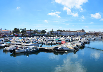 Boats at the marina of Faro with water reflection of clouds, Algarve, Portugal