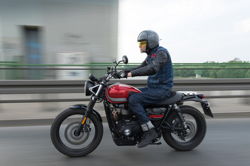 Obraz na płótnie Canvas Man riding fast red motorcycle on the bridge