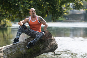 Muscular Man After Exercise Resting Outdoors In Nature