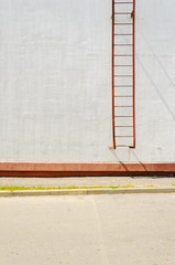 Element of building facade with fire escape. White plaster wall texture. Mockup template. Empty wall blank space.