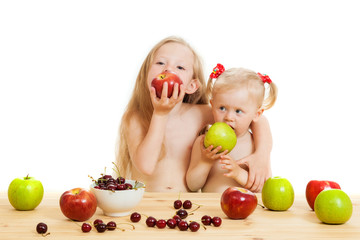 Fototapeta na wymiar two little girls eat fruit