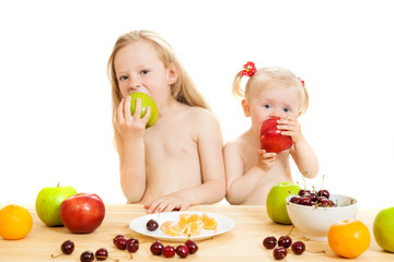Fototapeta na wymiar two little girls eat fruit