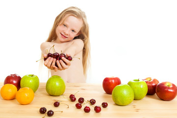Fototapeta na wymiar the little girl is fruit at a table