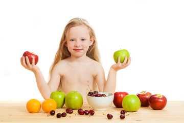 Fototapeta na wymiar the little girl is fruit at a table