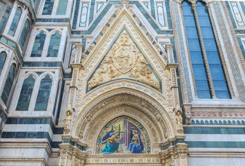 Fototapeta na wymiar Porta della Mandorla, located on north side of cathedral in Florence. Door takes its name from almond-shaped motif, which contains image of Virgin of Assumption. Marble bas-relief by Nanni di Banco 