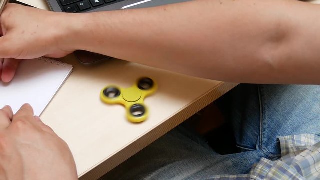 Toy for Increased Focus And Stress Relief. Hand Finger Spinner Spins on the Table in the Office. Stress Anxiety Relief Toy