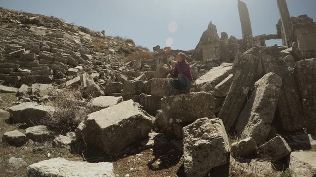 Girl Sits and Takes Fhoto in Ruins of Scene of Grandiose Antique Ruinous Roman Theatre Sagalassos