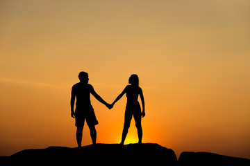 Fototapeta na wymiar Silhouette of attractive confident half naked man and woman holding hands