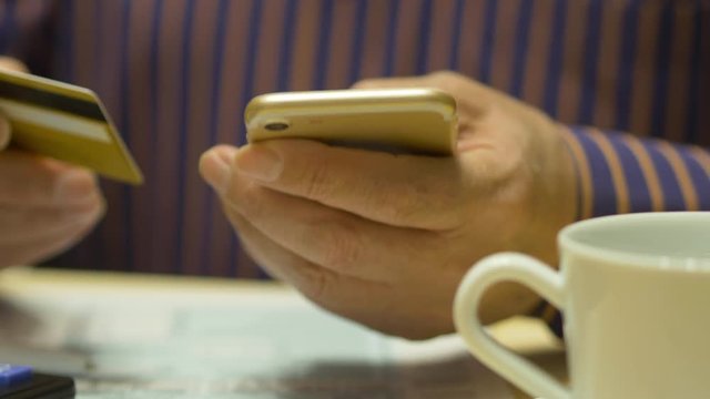 Elderly Man Text Messaging On Smartphone And Tax Form 1040, Credit Card