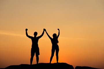 Silhouette of attractive confident half naked man and woman holding hands