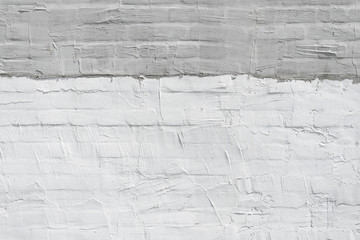 Thin layer of plaster on a brick wall. White and gray plaster wall texture. Empty background