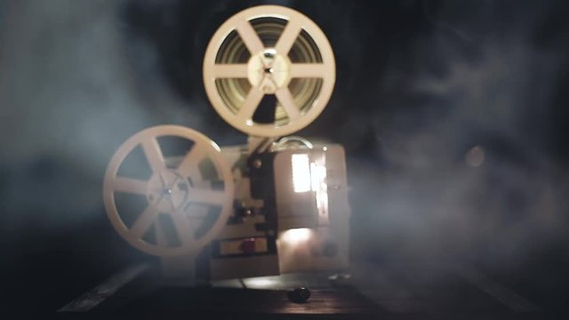 Old antique film projector is working in a smoke