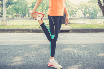 Attractive confidence asian woman runner doing a leg stretch before a run