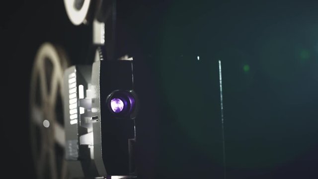 Old film projector working in dark space. 4K