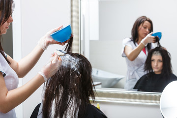 Woman getting hair colored in beauty salon