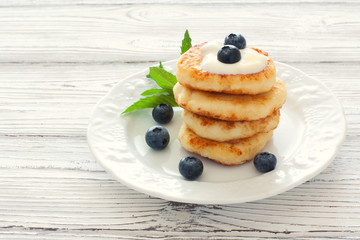 Delicious cottage cheese pancakes or syrniki with fresh blueberry