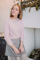 Soft photo of fresh young woman in pink tender sweater smiling. Pretty girl enjoying early sunny morning at home.