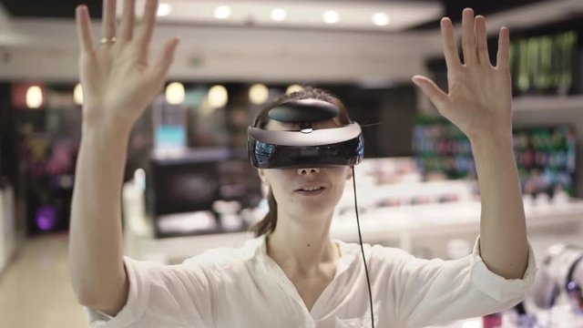 Young woman getting experience in using vr-headset in a mall