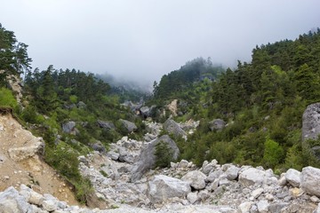 Горный пейзаж, красивый вид на живописное ущелье в облаках, пасмурная погода, природа Северного Кавказа