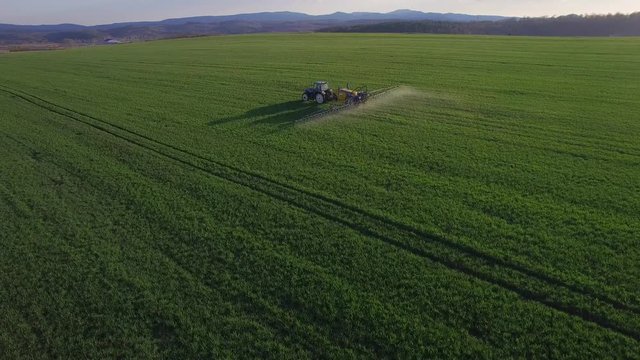 Drone flying over the spraying tractor