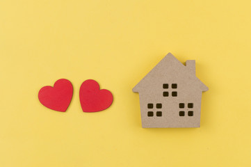 Wooden house toy and paper box red heart shape on black background with copy space.Real estate concept, New house concept, Love house concept, Finance loan business concept