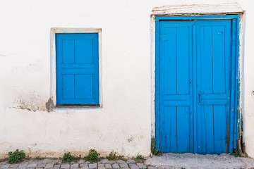 Whitewashed wall with blue painted wooden door and window