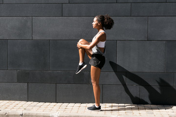 Side view of female athlete stretching leg