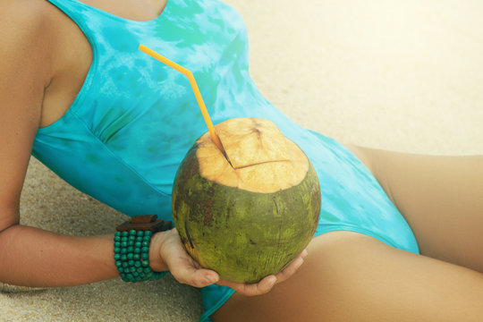 Woman with a coconut on the beach