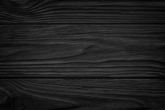 black wooden abstract background with light and scratches, dark wood texture