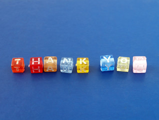 colourful plastic cube block arranged to word thank you with copy space