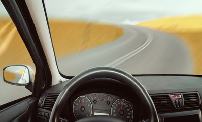 View from the interior of a car driving on an asphalt road ,vintage retro color tone