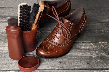 Shoe wax and brushes on wooden surface